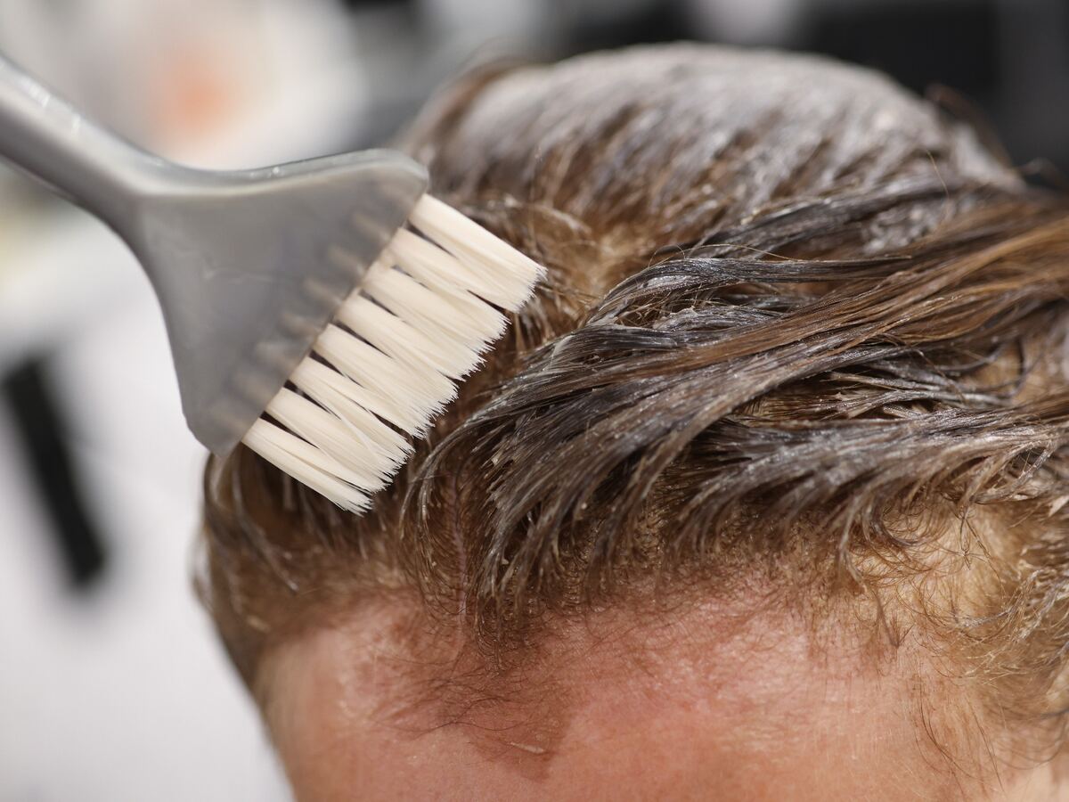 Aplicación de tinte con pincel en la raíz del pelo