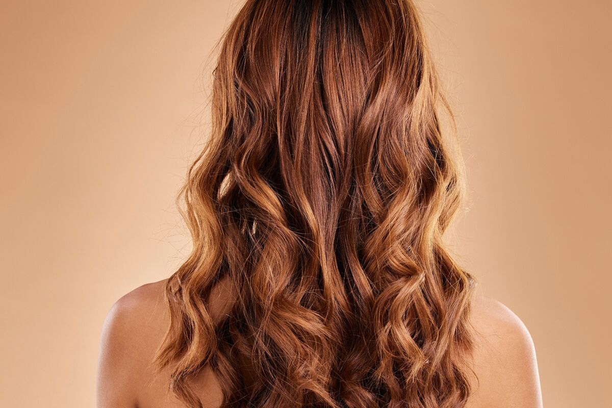Melena ondulada con mechas balayage en tonos caramelo, vista de espaldas